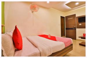 1 dormitorio con 1 cama con almohadas rojas y ventilador en Hotel S-R Palace Near City Bus Stand - Fully Air Conditioning Hotel - Luxury & Spacious Room -Best Hotel In Bhubneshwar, en Cuttack