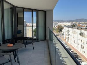 a balcony with a table and a view of a city at Luxurious Apartment with Sea View, Pools, Fitness in Olhão