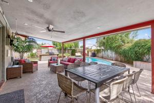 a patio with a table and chairs and a pool at Pineapple Oasis - Heated Pool, ASU, Sleeps 12 in Tempe