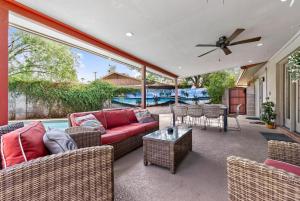 a patio with a couch and chairs and a table at Pineapple Oasis - Heated Pool, ASU, Sleeps 12 in Tempe