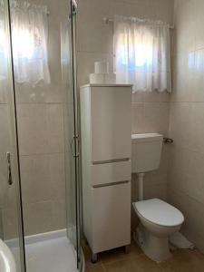 un bagno bianco con wc e doccia di Pomares Country House a Paderne Altre 17 foto