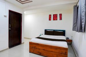 a bedroom with a bed and a door in it at Hotel O Pearl Inn Executive in Chakan