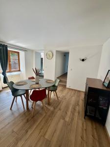 een woonkamer met een tafel, stoelen en een klok bij L'Appart De Papa in Saverne