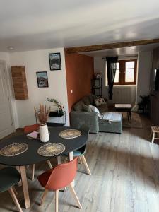 een woonkamer met een tafel, stoelen en een bank bij L'Appart De Papa in Saverne +13 foto's