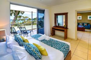 a bedroom with two beds and a balcony at Blue Water Views Apartments in Hamilton Island