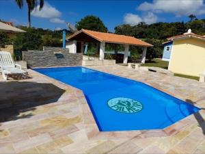 a large blue swimming pool in a yard at Recanto das palmeiras 2 in São Thomé das Letras
