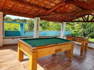 a pool table in the middle of a patio at Recanto das palmeiras 2 in São Thomé das Letras