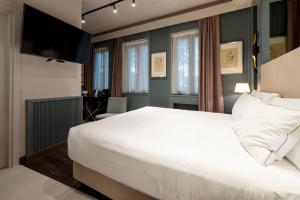 a bedroom with a large white bed and a desk at The Glam Boutique Hotel & Apt in Vicenza