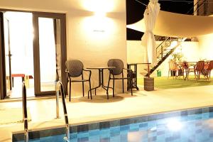 a pool with chairs and a table next to a swimming pool at Casa do Campinho B&B boutique country house in Reguengos de Monsaraz