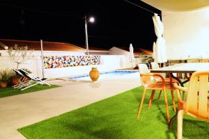 a patio with a table and chairs and a pool at Casa do Campinho B&B boutique country house in Reguengos de Monsaraz