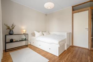 une chambre blanche avec un lit blanc et une fenêtre dans l'établissement Urban Architectural Retreat, à Tromsø