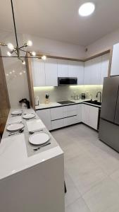 a large kitchen with white cabinets and a refrigerator at Luxury apartment 2 minutes from BBVA Stadium in Monterrey