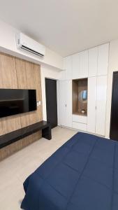 a living room with a tv and a blue rug at Luxury apartment 2 minutes from BBVA Stadium in Monterrey