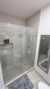 a bathroom with a glass shower with a toilet at Luxury apartment 2 minutes from BBVA Stadium in Monterrey