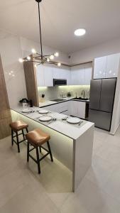 a kitchen with a white counter and chairs in it at Luxury apartment 2 minutes from BBVA Stadium in Monterrey