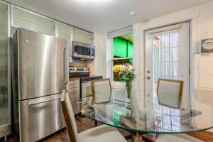 a kitchen with a glass table and a refrigerator at Artful 3BR in Montreal Village in Montréal