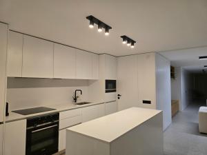a kitchen with white cabinets and a sink at SecretWaters Studio in São Jacinto