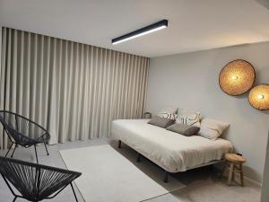 a bedroom with a bed and a chair in it at SecretWaters Studio in São Jacinto