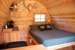 a bedroom with a bed in a log cabin at Cosy Cabin Overloon in Overloon