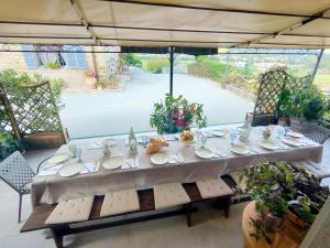 een lange tafel met borden erop voor een raam bij Agriturismo L'Essiccatoio in Lisciano Niccone