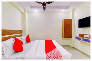 a bedroom with a bed with red pillows and a tv at Hotel Nandan- Residency Near Bus Stand-Nandankanan Zoo- Fully Air Conditioning Hotel - Luxury & Spacious Room -A Premium Hotel in Cuttack