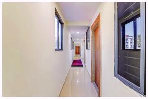 a hallway with white walls and windows and a hallway with a hallway at Hotel Nandan- Residency Near Bus Stand-Nandankanan Zoo- Fully Air Conditioning Hotel - Luxury & Spacious Room -A Premium Hotel in Cuttack
