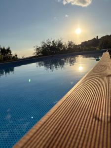 una piscina con puesta de sol en el fondo en Ca’del Borgo B&B Country House, en Ogliastro Cilento