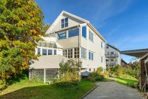 Cette grande maison blanche est dotée de fenêtres bleues. dans l'établissement Urban Architectural Retreat, à Tromsø