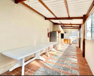 a long white table in a room with windows at Edificio Club del Mar in Punta del Este