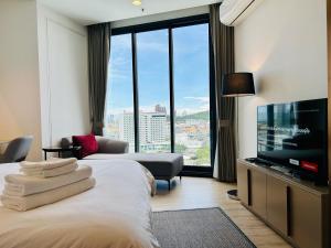 a hotel room with a bed and a flat screen tv at Edge Central Pattaya By YoYo in Pattaya Central