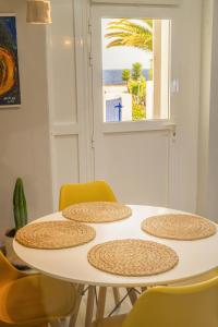 una mesa blanca con sillas amarillas y una ventana en Volcán de sal, en Teguise