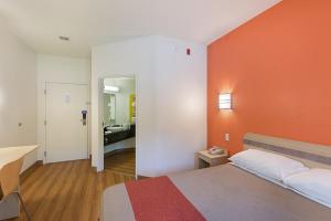 a hotel room with a bed with an orange wall at Columbia - Fort Jackson in Columbia +9 photos