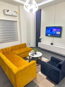 a living room with a yellow couch and a tv at OccaLuxe in Adgénou