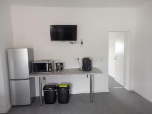 a kitchen with a table with a microwave and a refrigerator at Monteurzimmer A Simon Haus 87 in Jülich