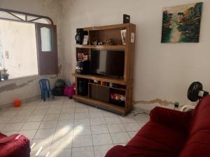 a living room with a couch and a flat screen tv at Quarto para solteiro perto do aeroporto e parques in Belém