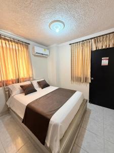 a bedroom with a large bed and a window at Hotel Buenavista Valledupar in Valledupar