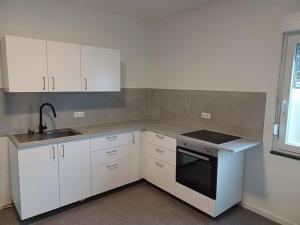 a kitchen with white cabinets and a sink at Monteurzimmer A Simon Haus 87 in Jülich