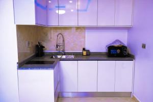 a kitchen with white cabinets and a sink at Seem Homes in Abuja
