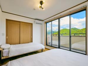美祢市にある美祢Terraceのベッドが2つと大きな窓がある寝室