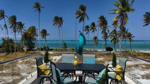 a table on a balcony with a view of the beach at Amani Forever Villa in Bwejuu