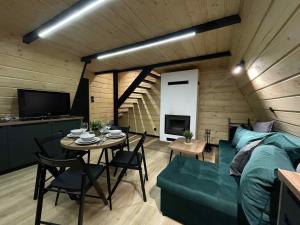 a room with a bed and a table and a couch at Brda 5 osobowa z jacuzzi in Zawoja