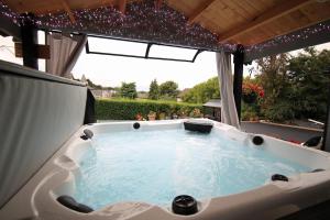 a hot tub in a gazebo with lights at Sunset Retreat Cabin, Hot Tub & Garden views in Portglenone
