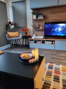a living room with a tv and a table with candles at Elegant 2 Bedroom En-Suite Caravan with Bathtub near Edinburgh Seton Sands Holiday Village in Port Seton