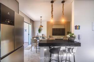 a kitchen with a black counter and chairs in a room at Estadia completa com piscina e a 350m da Praia PRY in Porto Seguro