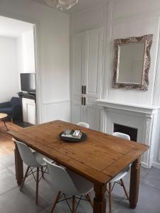 een eetkamer met een houten tafel en stoelen bij Maison cosy proche saint-leu et centre-ville in Amiens +1 foto