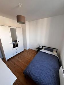 een slaapkamer met een bed, een ladekast en een spiegel bij Maison cosy proche saint-leu et centre-ville in Amiens