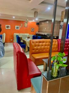 a restaurant with a red chair and a table at Hotel bougainvillea Victoria island in Lagos