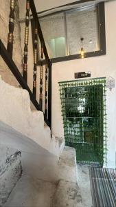 a staircase with a green gate in a building at Zaloğlu Oda in Midyat