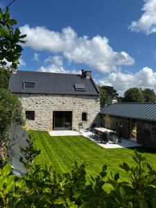 a stone house with a lawn in front of it at Charmant corps de ferme - Proche de la mer in Plougonvelin