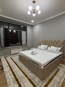 a bedroom with a large bed and a window at Assu in Taraz